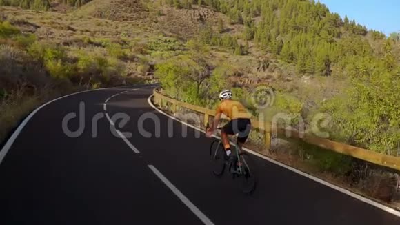 追踪一名男子骑自行车爬上山路的录像在丘陵公路上骑自行车训练的人视频的预览图