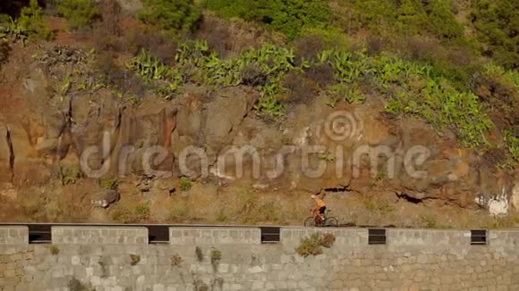 追踪一名男子骑自行车爬上山路的录像在丘陵公路上骑自行车训练的人视频的预览图