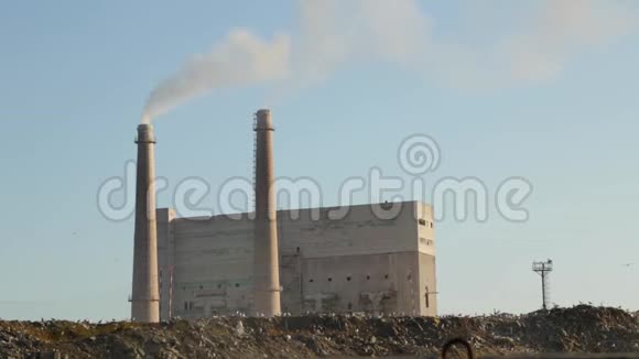 城市垃圾场工厂背景上的垃圾场恶臭烟雾来自工厂管道环境污染视频的预览图