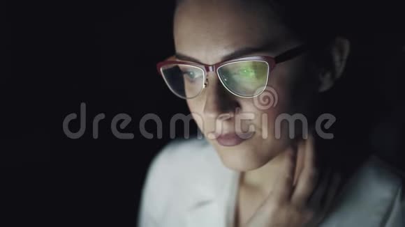 有眼镜的工作监视器的反射商业女性在黑暗中在电脑上工作视频的预览图