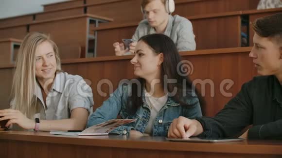 一群开朗快乐的学生在课前坐在报告厅里一群快乐的学生坐在视频的预览图