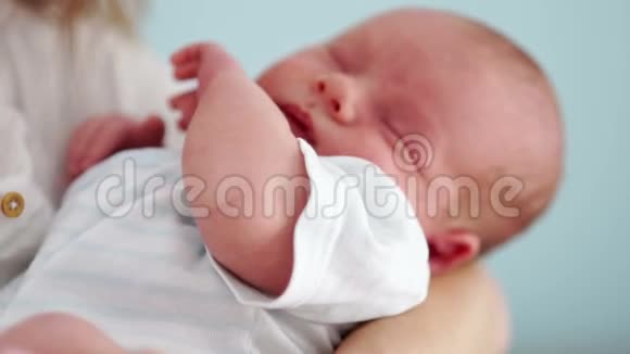 新生儿的肖像他和他的母亲睡在怀里在睡梦中移动手柄儿童节视频的预览图