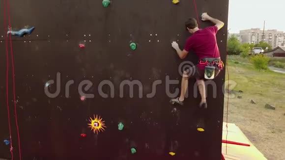 登山者的空中运行速度攀岩轨道上的人造墙户外年轻的快运动员在悬崖上爬视频的预览图
