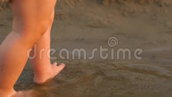 孩子们的腿在沙滩上玩水慢动作视频的预览图
