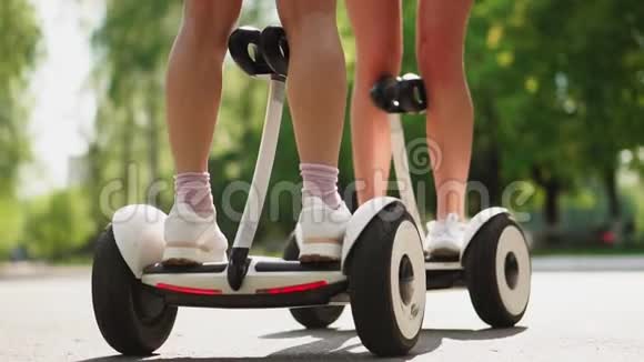 镜头从下到上穿短裤的女孩站在白色自平衡滑板车上视频的预览图