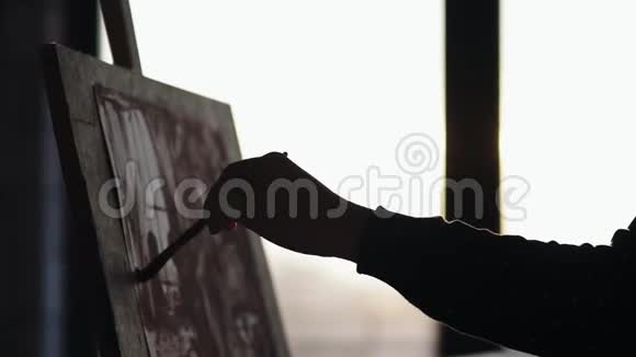 完全集中的老练的女艺术家在她20的画架上画着画慢镜头关闭镜头视频的预览图