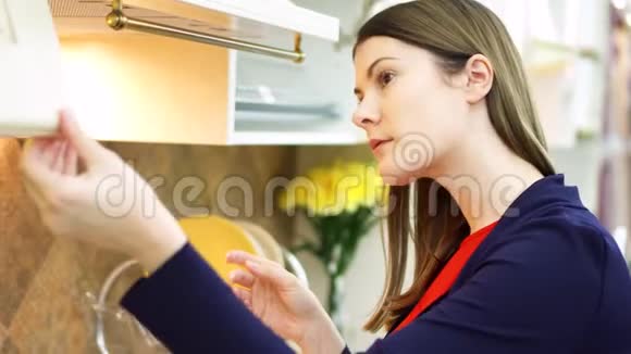 在家具店检查厨房设备的女人现代厨房陈列室女性开放橱柜视频的预览图