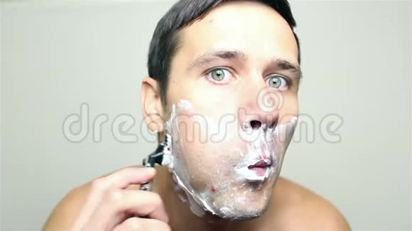 年轻的帅哥用剃刀刮脸视频的预览图