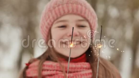 一个快乐的年轻女学生在冬天的森林里闪耀着孟加拉灯的火花面的特写在世界末日前夕视频的预览图