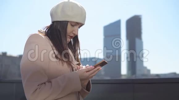 在大城市高楼背景下打电话的年轻女子视频的预览图