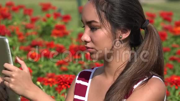 青少年女性用平板电脑拍摄视频的预览图