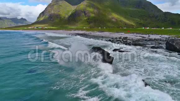 令人惊叹的4k空中无人驾驶飞机慢动作拍摄的蓝色海水海浪拍打在沙滩山地景观的石头上视频的预览图