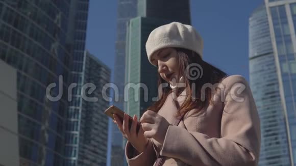 在大城市高楼背景下打电话的女人视频的预览图