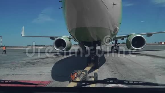 一架客机在机场机库后撤飞机机头起落架和拖运车关闭视频的预览图