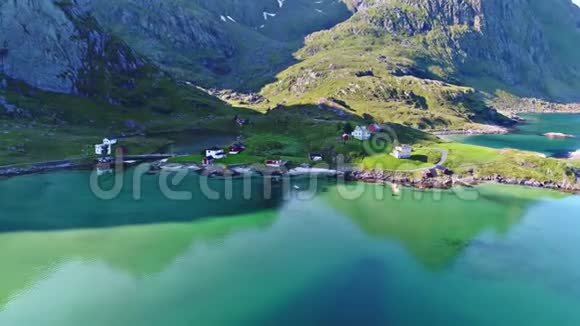 在青山绿水的青山上飞越小山村在平静的蓝镜面湖上飞越4k空中景观全景视频的预览图