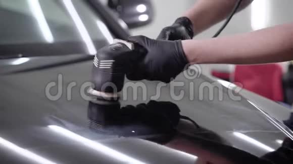 近距离拍摄一名男子打蜡黑色汽车引擎盖使用特殊机器视频的预览图