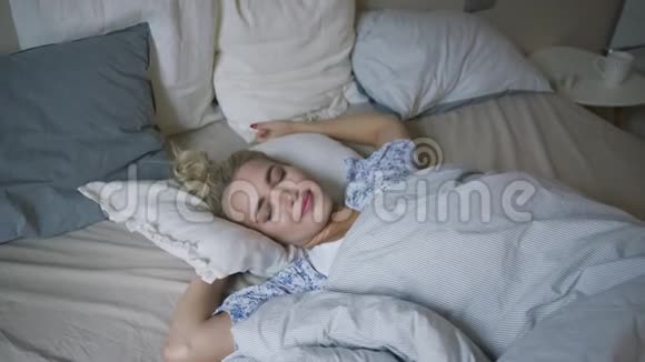 女人在床上伸展手臂视频的预览图