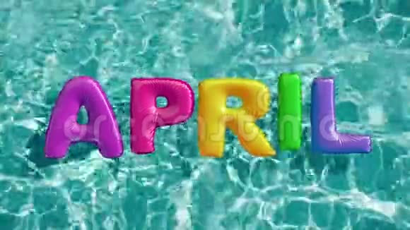 4月消息种形状的充气游泳圈漂浮在清爽的蓝色游泳池里视频的预览图