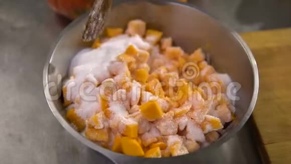 厨师用勺子把撒满糖的小南瓜片混合在盘子里视频的预览图