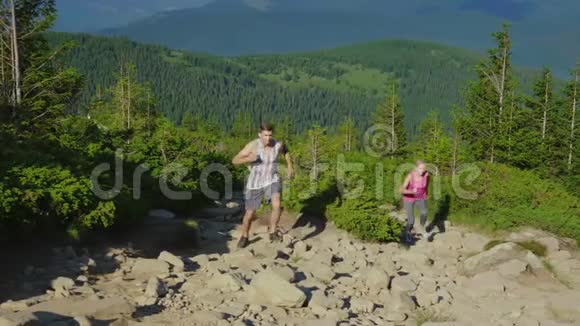 极度奔跑一个带私人教练的女人在山上跑上一条陡峭的山路视频的预览图