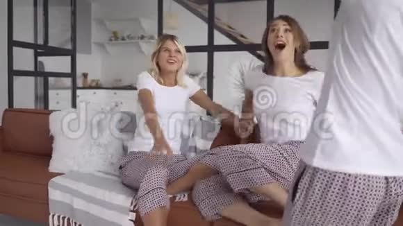 三个穿着同一件睡衣的快乐女朋友一起在家里喝酒派对睡衣派对女孩视频的预览图