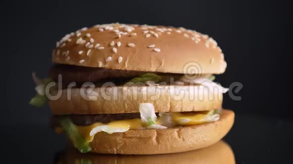 两个多汁的馅饼和调味品的开胃双奶酪汉堡的特写镜头视频的预览图