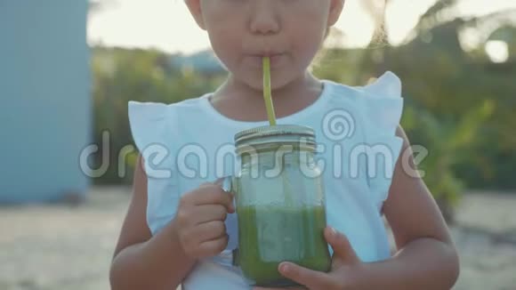 可爱的小女孩慢动作在户外喝冰沙的肖像视频的预览图