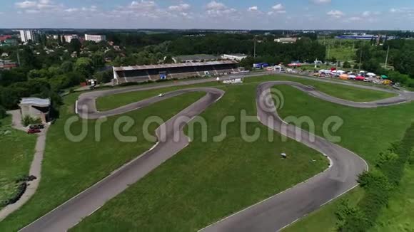 从高处俯瞰蜿蜒的赛车跑道靠近城市的湖泊和法庭慢动作视频的预览图