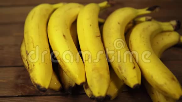 成熟的湿香蕉躺在木桌上视频的预览图
