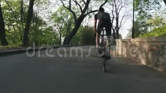 强壮的专业骑自行车的人骑着上坡离开马鞍强壮的腿部肌肉蹬自行车视频的预览图
