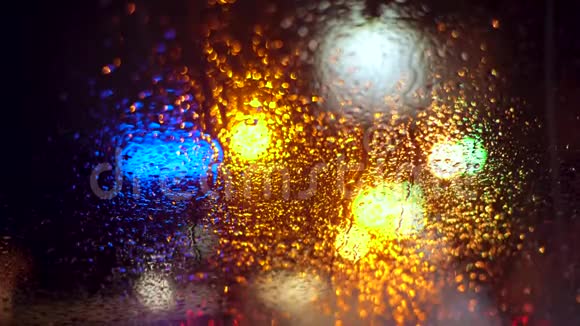 将车窗玻璃上的雨滴与模糊的夜晚城市车灯结合起来作为背景视频的预览图