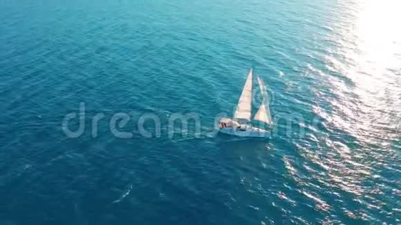 在海洋中的帆船白色帆船在无边无际的海洋中间空中观景视频的预览图