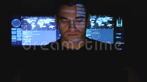 开发人员在数据中心的计算机上工作而蓝码字符在黑暗中反射他的脸视频的预览图