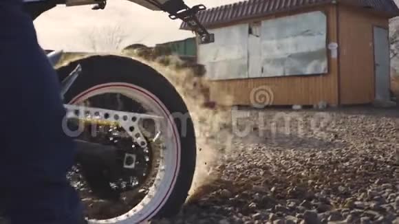 摩托车手在沙漠中做轮胎烧坏慢动作职业摩托车手在地面上颠簸着开着摩托车视频的预览图
