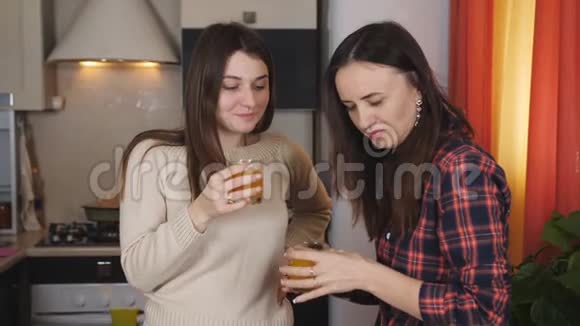 两个女人在厨房喝橙汁说话视频的预览图
