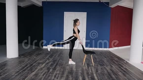 穿着深色运动服的健身年轻女子独自在健身房训练她正在做一种俯卧撑视频的预览图