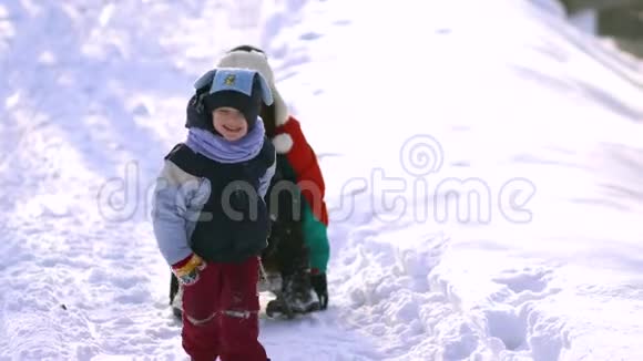 妈妈和小儿子在雪地里玩得很开心他们坐雪橇视频的预览图