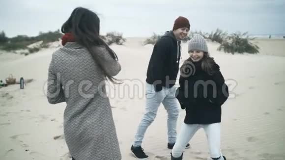 女儿在海滩散步时在父母面前跳舞年轻幸福的家庭度假视频的预览图