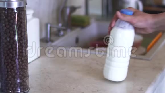 男人正在厨房里开一瓶牛奶视频的预览图