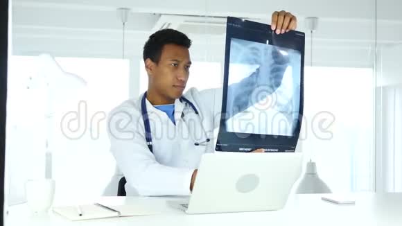 美国黑人医生检查病人肺和胸腔的x光片视频的预览图