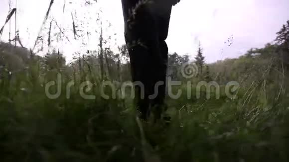人走在湿漉漉的草地上视频的预览图