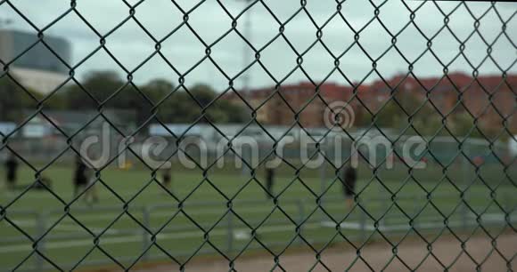 一群模糊的男孩在哥西亚杯上练习足球前景的绿色围栏视频的预览图