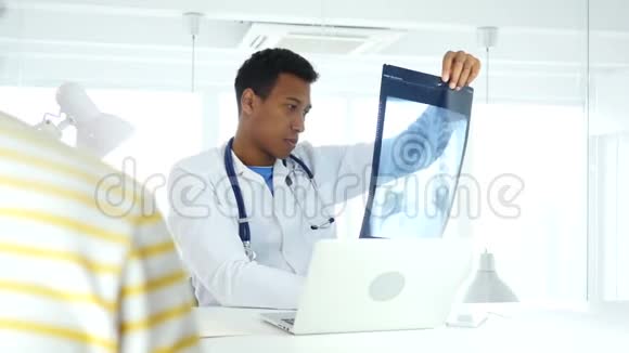 非裔美国医生检查X线诊断病人坐在前面视频的预览图
