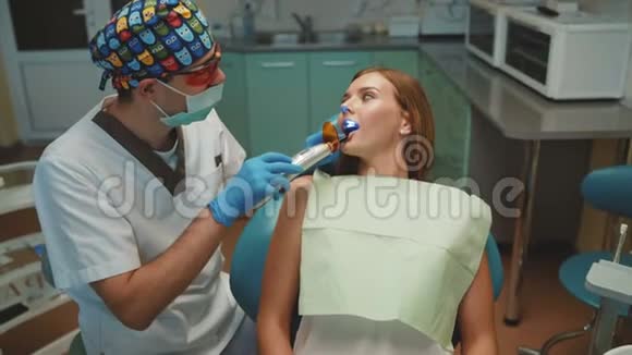 年轻漂亮的女孩在牙科柜里接受治疗和洁牙视频的预览图