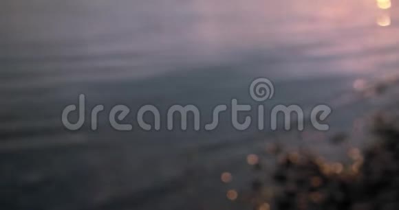 粉红色和紫色的水橙色的光反射在海岸上视频的预览图