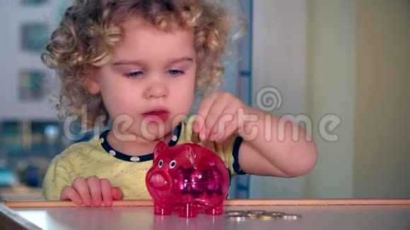 可爱的小女孩把欧元硬币放进储蓄罐里视频的预览图