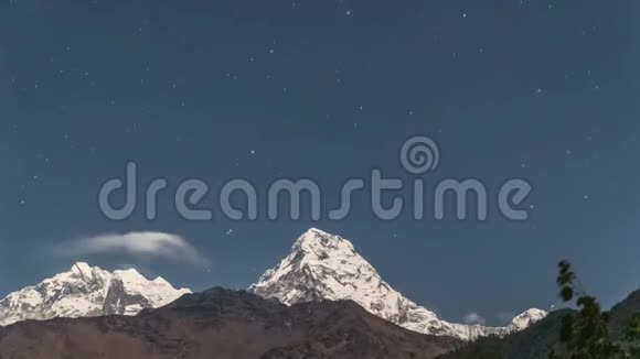 在尼泊尔的喜马拉雅山上安那普尔纳山的雪峰与移动的星星在夜间时间推移视频的预览图