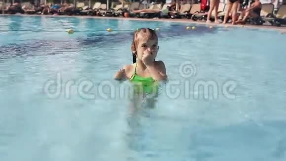 小女孩在游泳池里玩第一次学会游泳在海滩度假胜地度过暑假视频的预览图