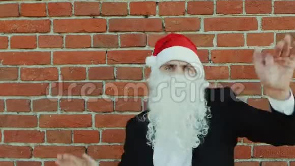 像圣诞老人一样的人在跳舞圣诞快乐2019年新年红砖墙作为背景视频的预览图
