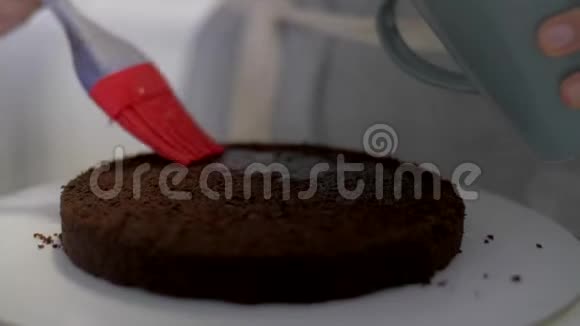 女性的手用烤刷把蛋糕浸湿视频的预览图